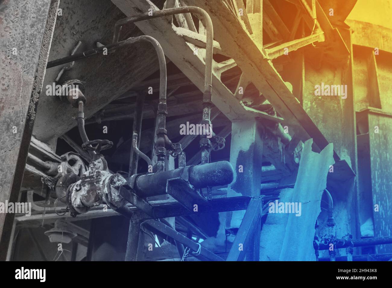 Vecchio sistema di tubazioni e unità di distribuzione con tubi per impianto industriale barile chimico liquido. Foto Stock