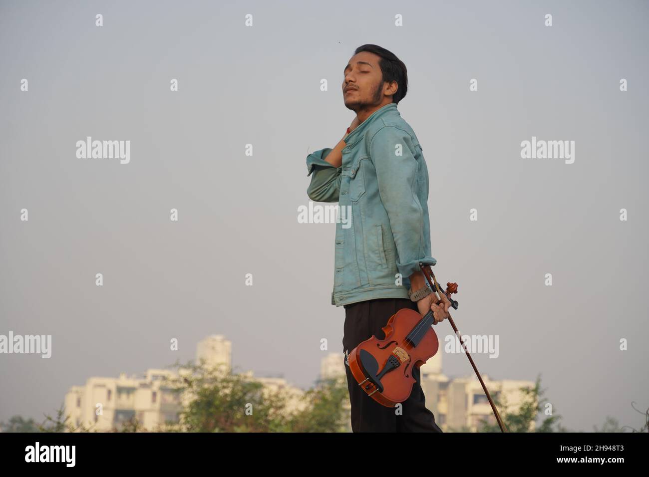 uomo indiano che pensa a suonare il violino Foto Stock