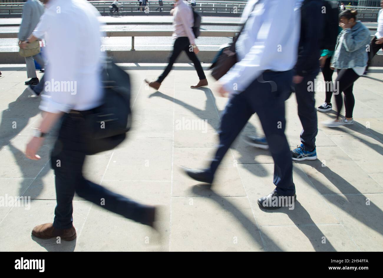 I lavoratori della città percorrono il London Bridge alla fine della giornata lavorativa durante il loro viaggio di ritorno a casa Foto Stock