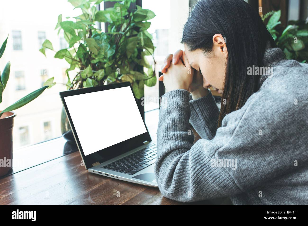 Esausto studente caucasico che lavora su un computer portatile, che soffre di mal di testa o emicrania. Foto Stock