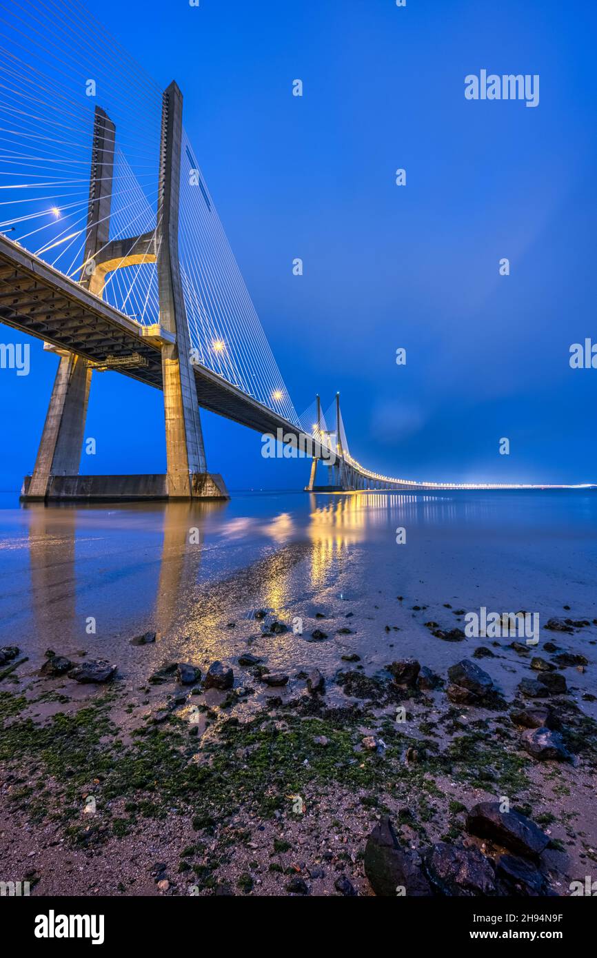 L'imponente ponte di Vasco da Gama, che attraversa il fiume Tago a Lisbona, in Portogallo, all'alba Foto Stock