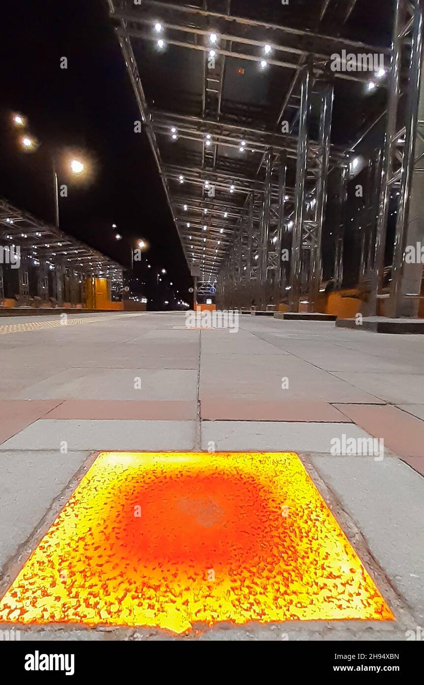 Sosta per i trasporti pubblici con intarsi decorativi sul pavimento e tetto lucido in ferro con colonne Foto Stock