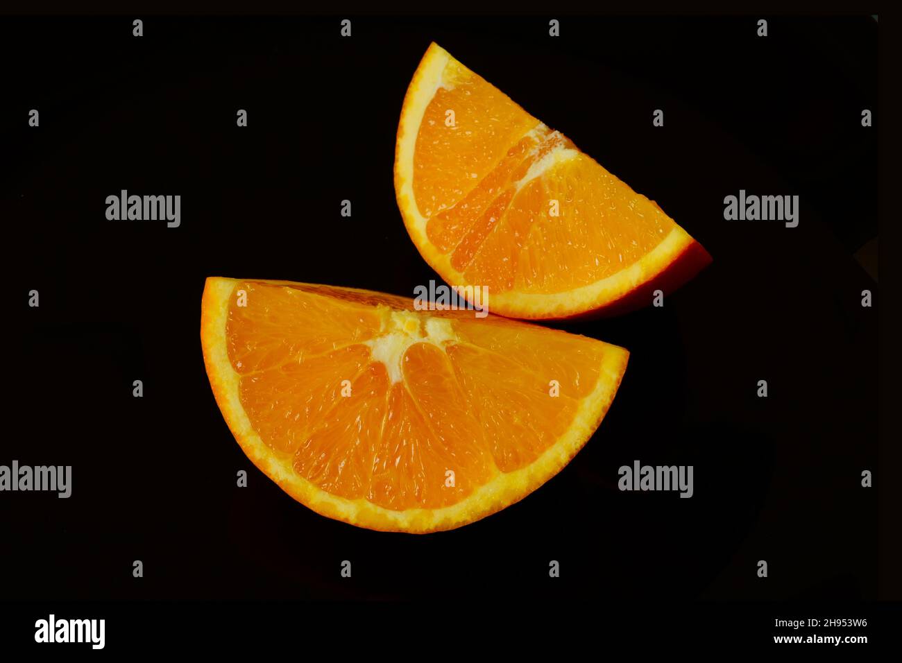 fette di arancio chiaro isolate in vista macro con sfondo nero. concetto di cibo sano. frutta e vitamine. stile di vita vegetariano. closeup estremo Foto Stock