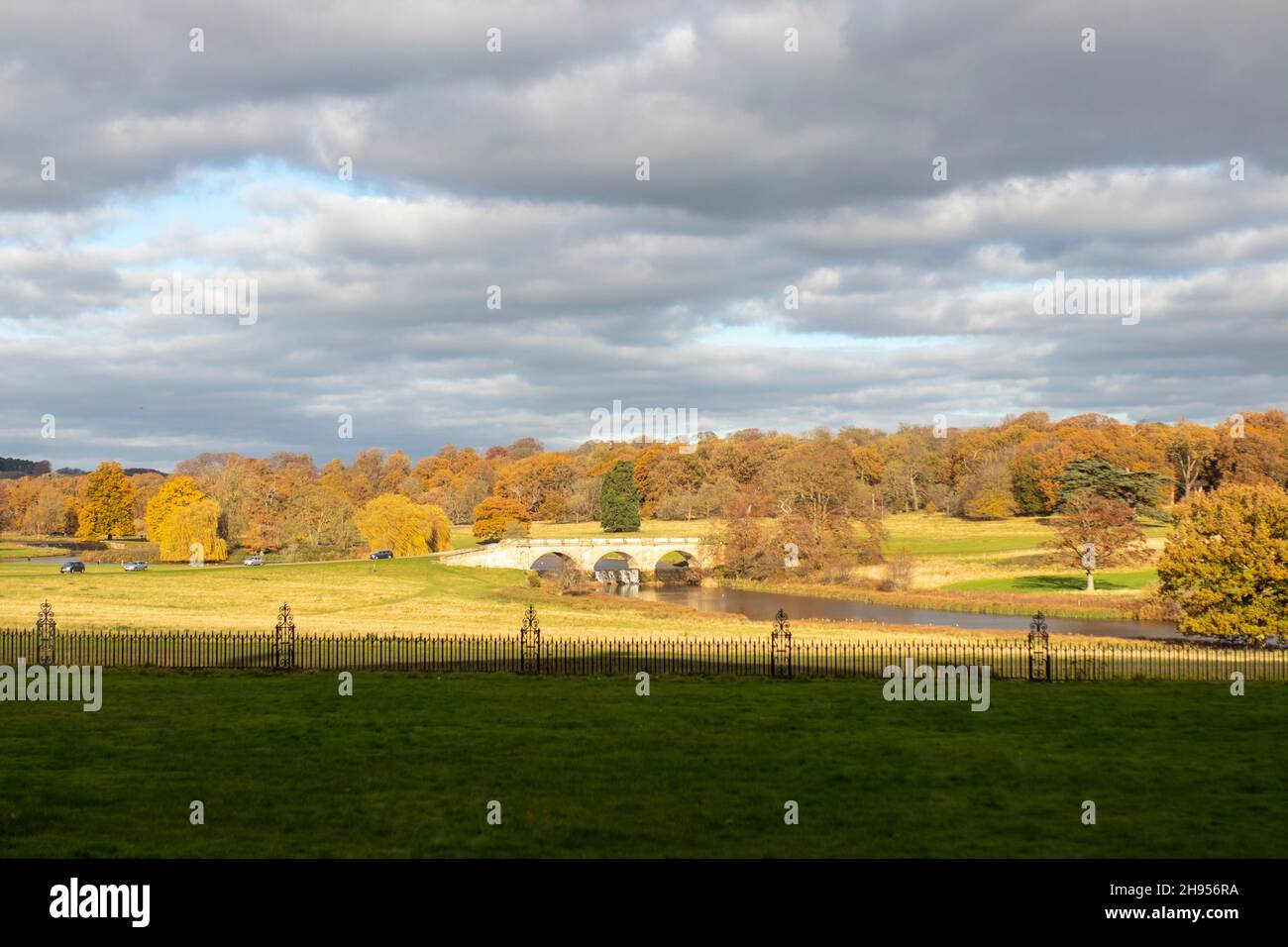 Vista distante del ponte di pietra alla luce del sole serale al Kedleston Hall Derbyshire Foto Stock