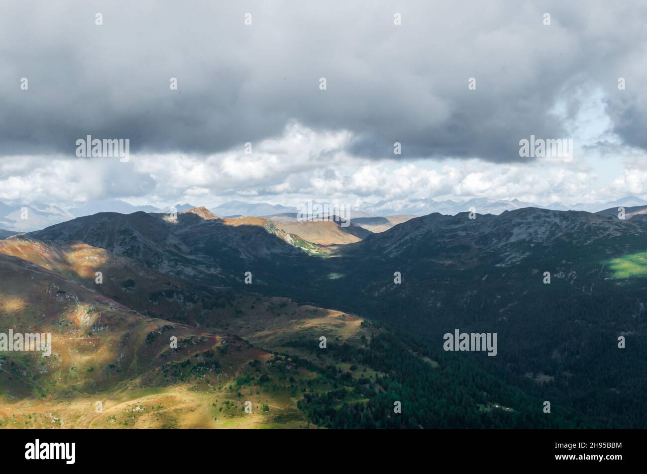 Paesaggio montagnoso in Austria. Vista da un punto alto di una catena montuosa. Giornata autunnale soleggiata con le nuvole drammatiche Foto Stock
