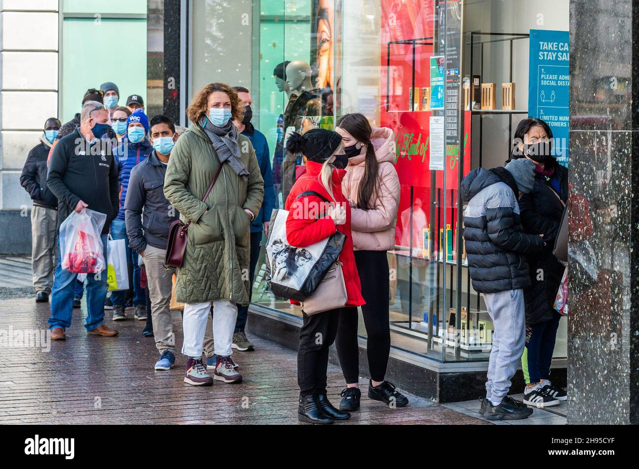 Cork, Irlanda. 4 Dic 2021. Persone che indossano maschere per il viso coda per entrare nel negozio di abbigliamento Penneys a Cork. Arriva come il governo ha imposto restrizioni sull'ospitalità e la miscelazione della famiglia fino al 9 gennaio. Credit: AG News/Alamy Live News Foto Stock