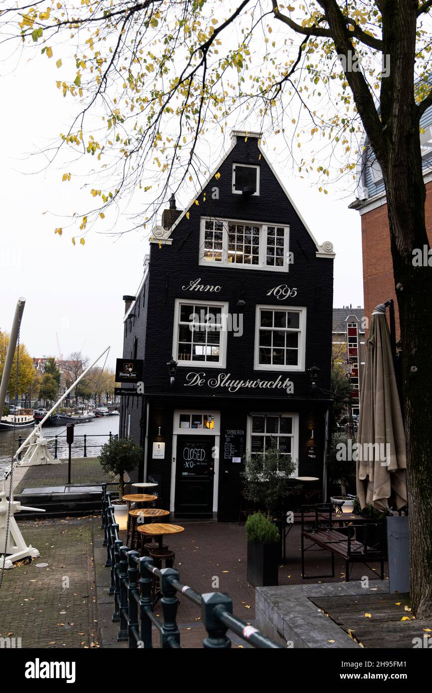 Il Café de Sluyswacht, una famosa lockhouse pendente dal 1695 a Jodenbreestraat lungo il canale di Amsterdam, Paesi Bassi. Foto Stock