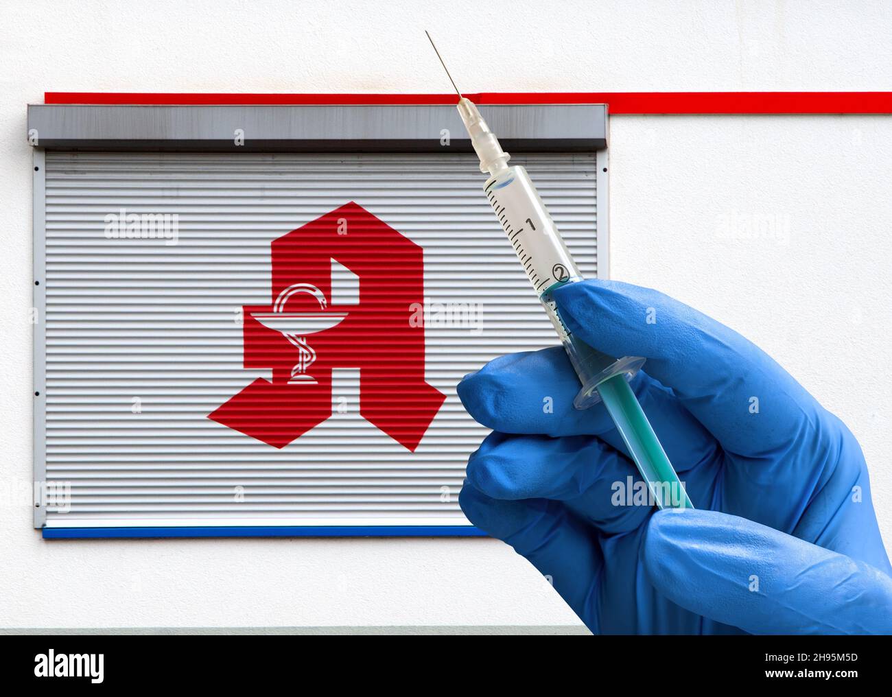 Logo della farmacia con mano e siringa. I farmacisti vaccinano contro Covid-19 da gennaio. Foto Stock Logo della farmacia con mano e siringa. I farmacisti vaccinano contro Covid-19 da gennaio. Foto Stock