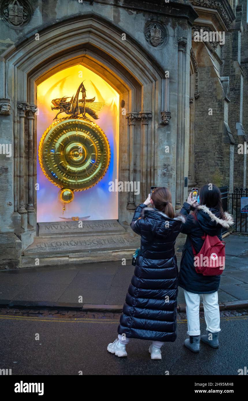 Due studenti stranieri cinesi scattano foto al tramonto del Corpus Clock al Corpus Christi College, Cambridge University, a Cambridge, Regno Unito. Foto Stock