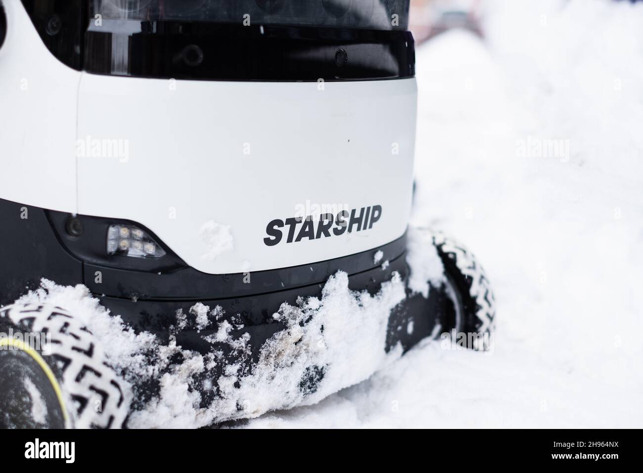 Tallinn, Estonia - 4 dicembre 2021: Veicolo con droni autonomi Starship Technologies che guida nella neve durante l'inverno. Robot di consegna a guida automatica. Foto Stock