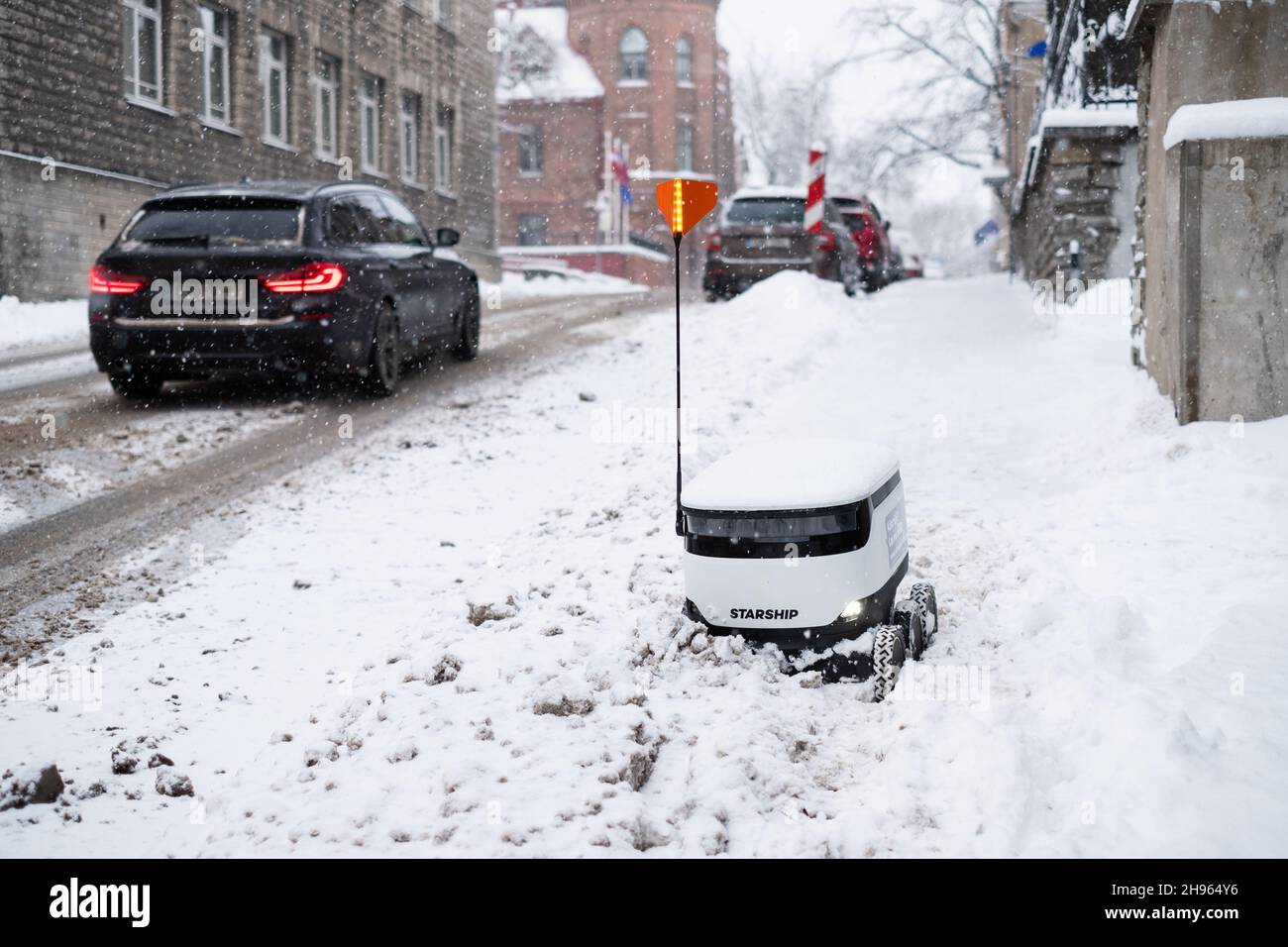 Tallinn, Estonia - 4 dicembre 2021: Veicolo drone autonomo Starship Technologies bloccato nella neve in inverno. Robot di erogazione senza contatto ad azionamento automatico. Foto Stock