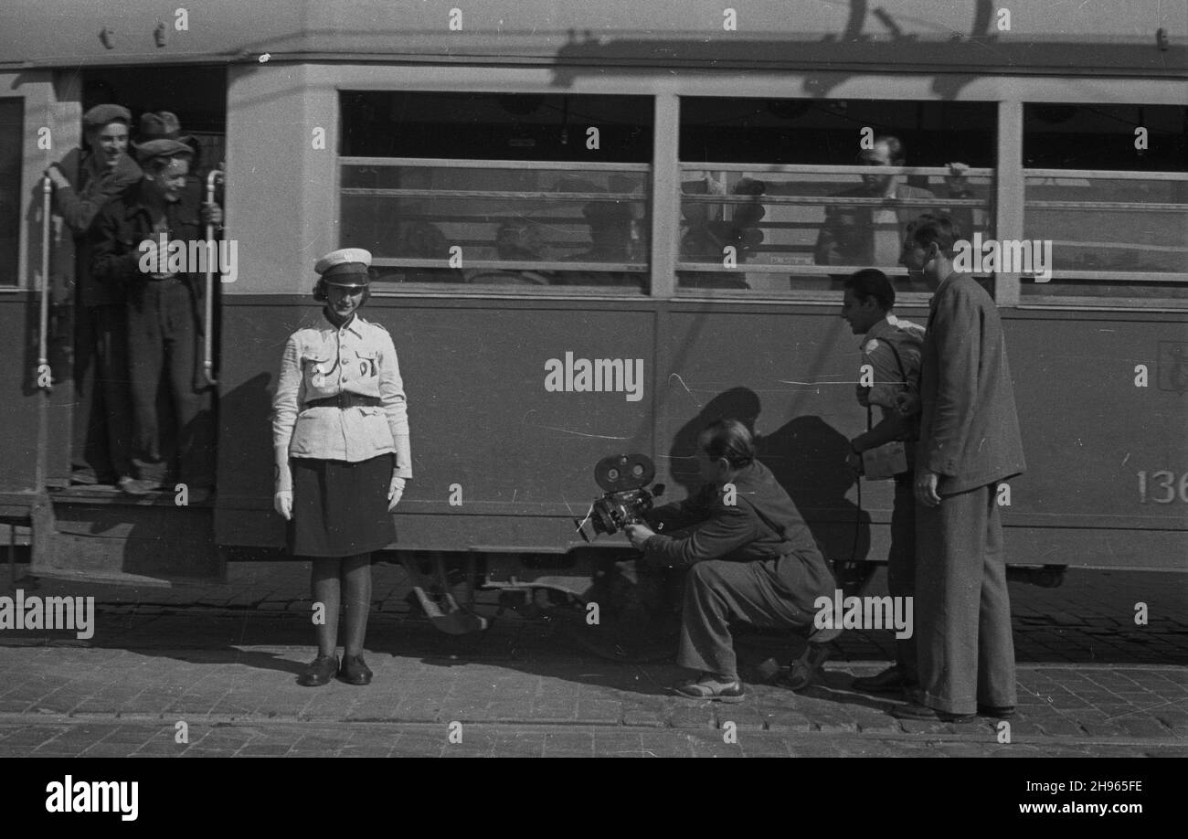 Warszawa, 1947-08. Ekipa Polskiej Kroniki Filmowej (m.in. Operatore W³adys³aw Forbert - 3P, asystent operatora Mieczys³aw Wiesio³ek - 1P) krêci film dokumentalny o milicjantce Lodzi, Leokadii Kubanowskiej z Kompanii Ruchu Drogowego, na skrzy¿owaniu ulicy Brackiej alej¹ wb Sikarskij Dok³adny dzieñ WB. Varsavia, 1947 agosto. Un team di newsreel polacchi (tra cui cameraman Wladyslaw Forbert - 3° a destra, cameraman assistente Mieczyslaw Wiesiolek - 1° a destra) spara un film documentario su Lodzia, poliziotto Leokadia Kubanowska della Road Traffic Company su i Foto Stock