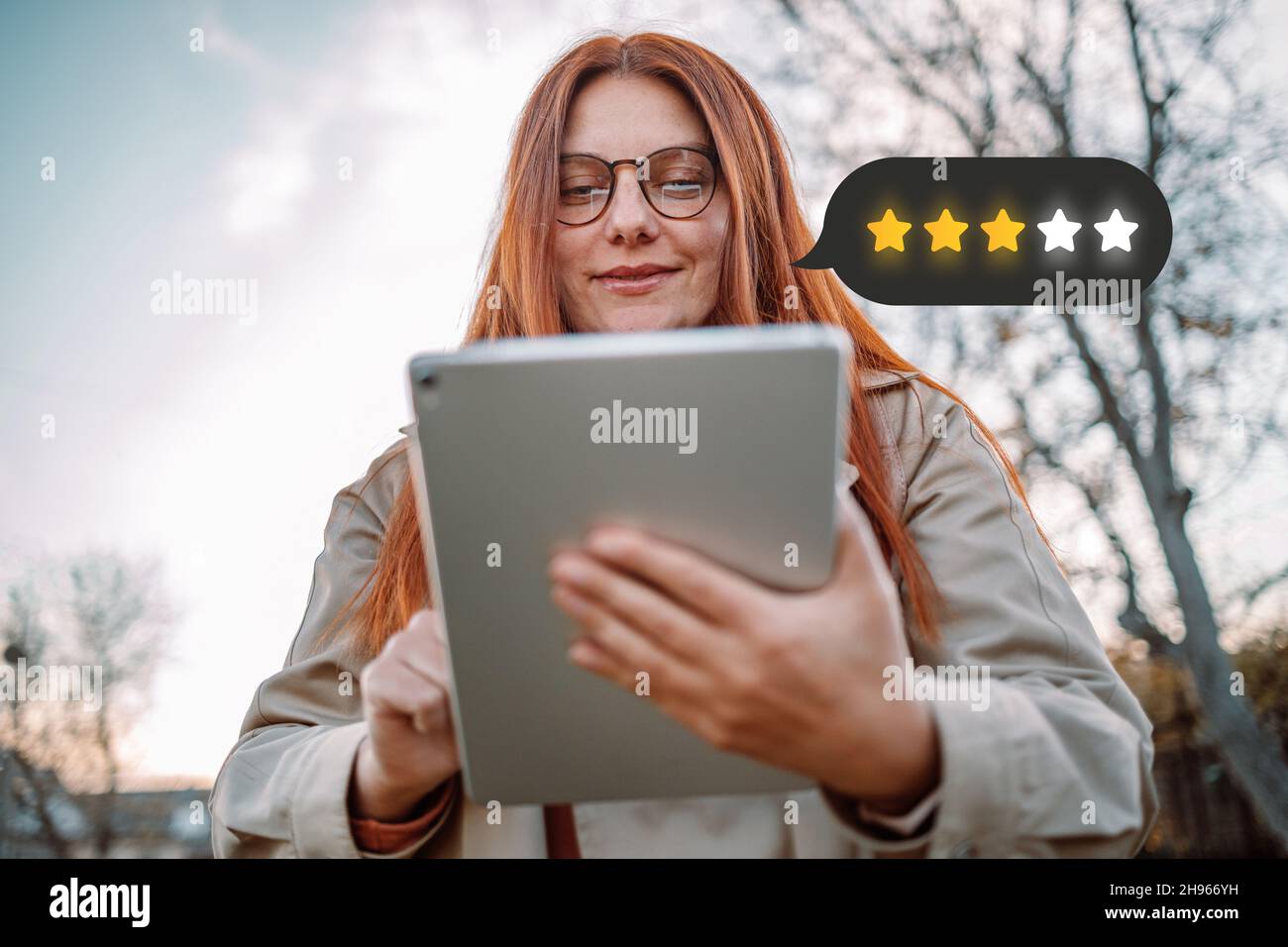 Il cliente esamina il concetto di valutazione ottimale. Eccellente. Persona che utilizza il blocco note del tablet con l'icona a 4 stelle per aumentare la valutazione dell'azienda Foto Stock