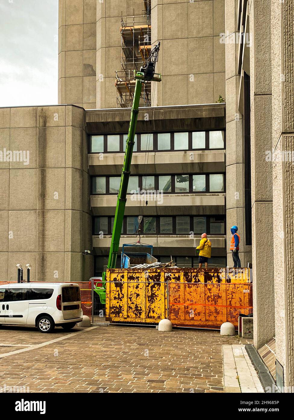 Due operai edili che lavorano con una gru in loco Foto Stock
