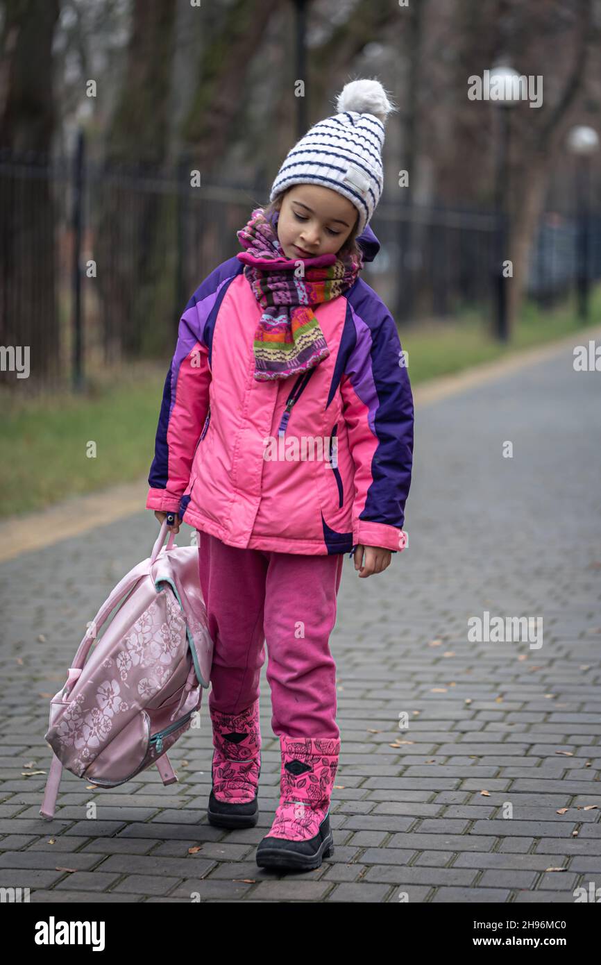 Bambina con zaino, in giacca e cappello vicino alla scuola Foto stock -  Alamy