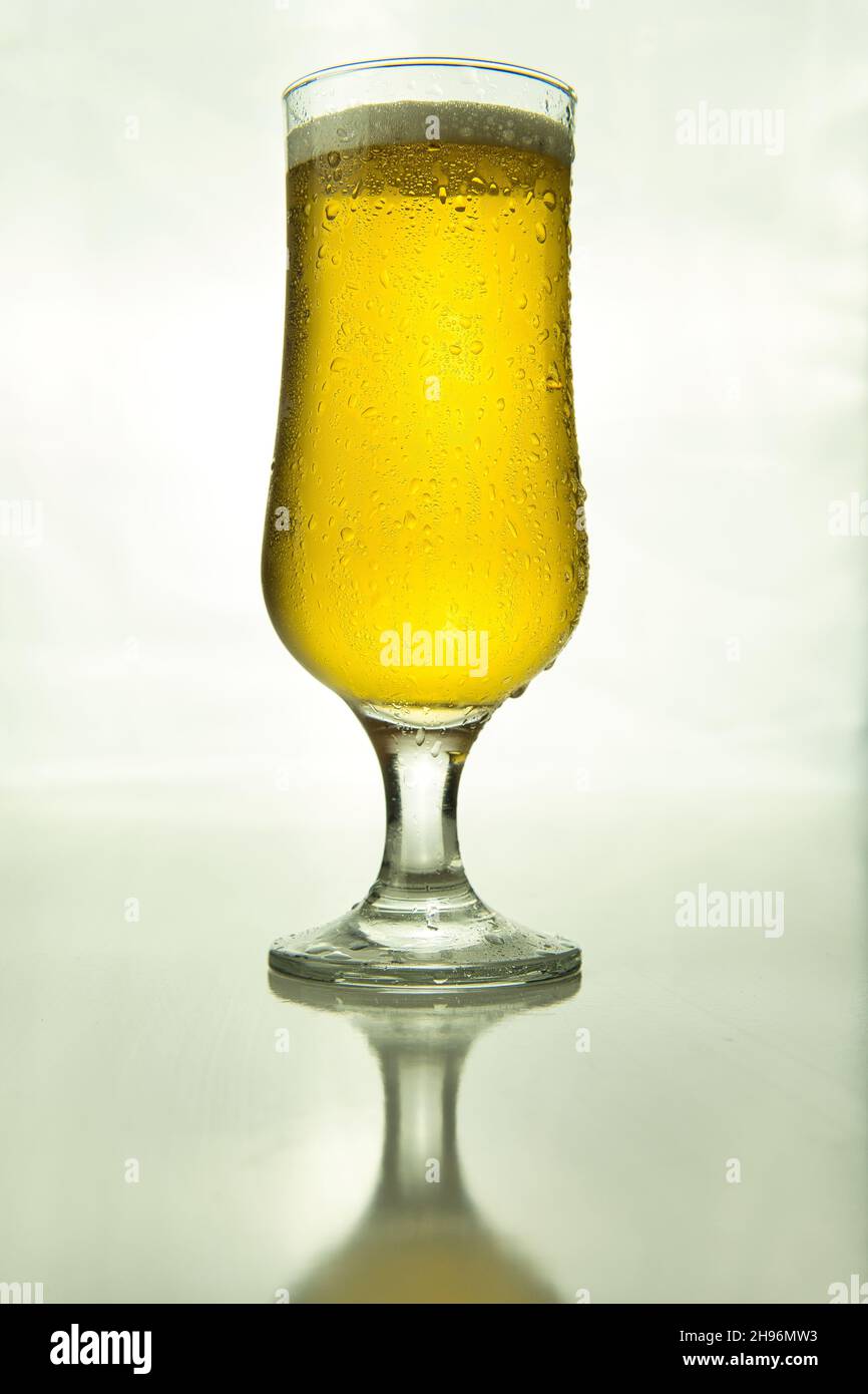 bicchiere di birra illuminato su sfondo bianco, prodotto Foto Stock