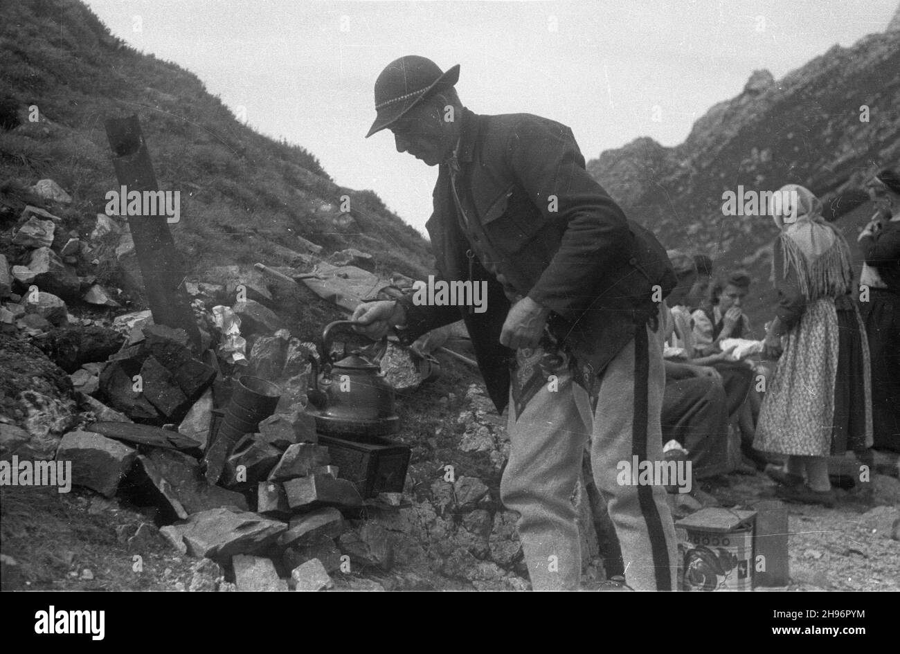 Polska, 1947-09. Tatry Zachodnie, Wy¿nia Kondracka Prze³êcz. góral Jan Kwatercarz, sprzedaj¹cy mleko i œmietanê turystom zmierzaj¹cym na Giewont, gotuje wrz¹tek na polowej kuchence. Z prawej góralka Anna Budrowa. bk/mgs PAP Dok³adny dzieñ wydarzenia nieustalony. Polonia, 1947 settembre. Monti Tatra Occidentali, Passo Wyznia Kondracka. Nella foto: highlander Jan Kwatercarz vendita di latte e crema ai turisti che arrampicano sul monte Giewont, acqua bollente su una stufa. Sull'altipiano destro Anna Budrowa. bk/MGS PAP Foto Stock