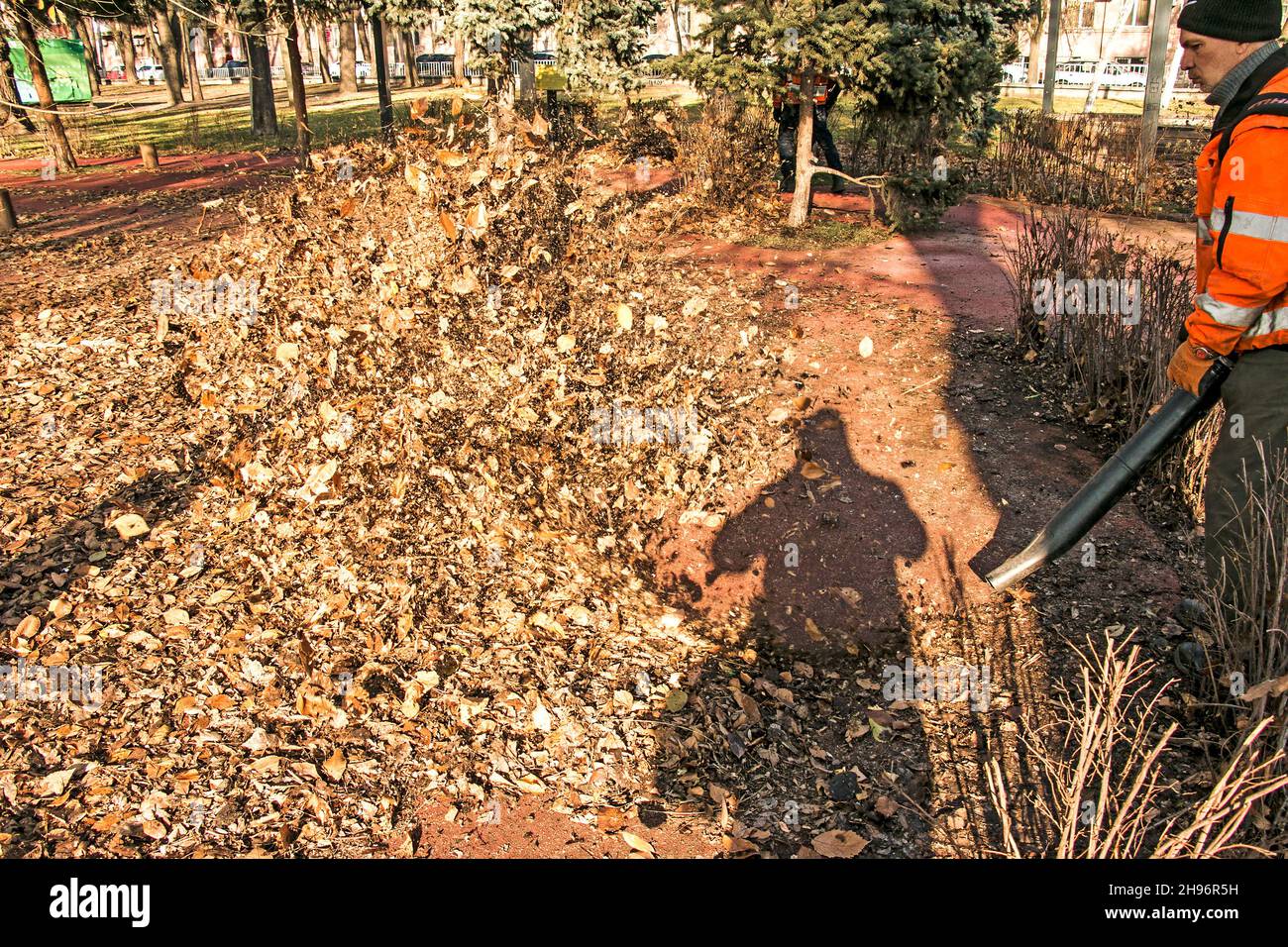 Dnepropetrovsk, Ucraina - 11.25.2021: Pulizia di foglie secche con un mulino a vento. Un lavoratore municipale pulisce il parco cittadino. Preparazione dei parchi cittadini per l'inverno Foto Stock
