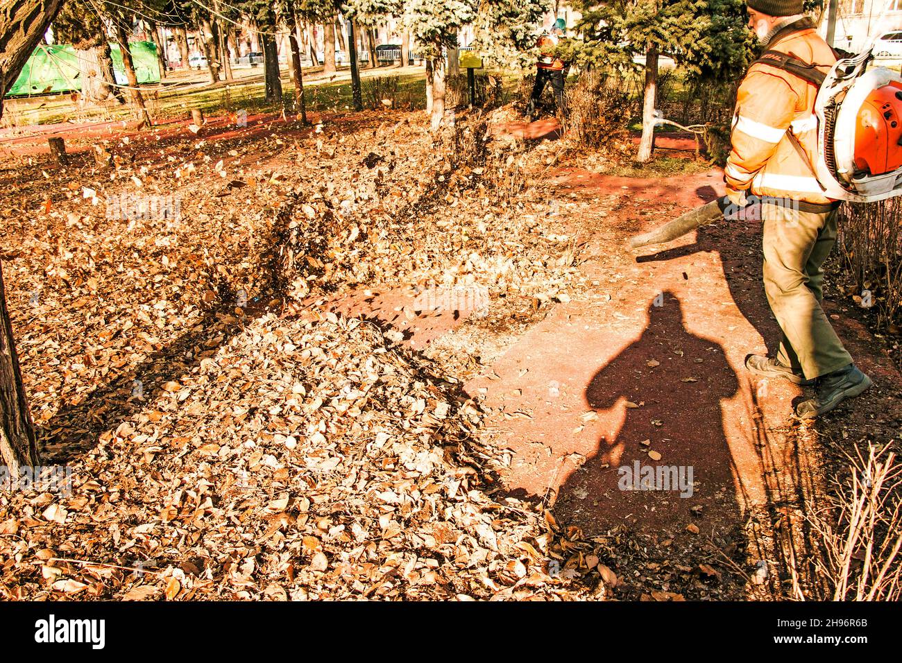 Dnepropetrovsk, Ucraina - 11.25.2021: Pulizia di foglie secche con un mulino a vento. Un lavoratore municipale pulisce il parco cittadino. Preparazione dei parchi cittadini per l'inverno Foto Stock