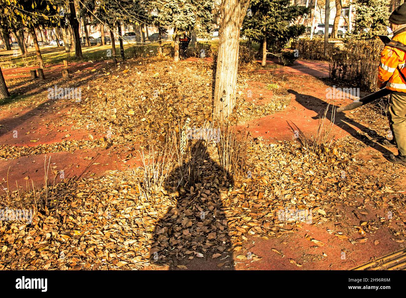 Dnepropetrovsk, Ucraina - 11.25.2021: Pulizia di foglie secche con un mulino a vento. Un lavoratore municipale pulisce il parco cittadino. Preparazione dei parchi cittadini per l'inverno Foto Stock