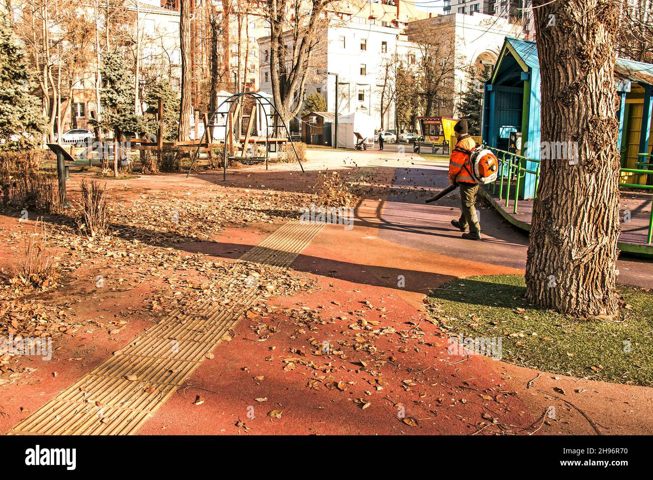 Dnepropetrovsk, Ucraina - 11.25.2021: Pulizia di foglie secche con un mulino a vento. Un lavoratore municipale pulisce il parco cittadino. Preparazione dei parchi cittadini per l'inverno Foto Stock