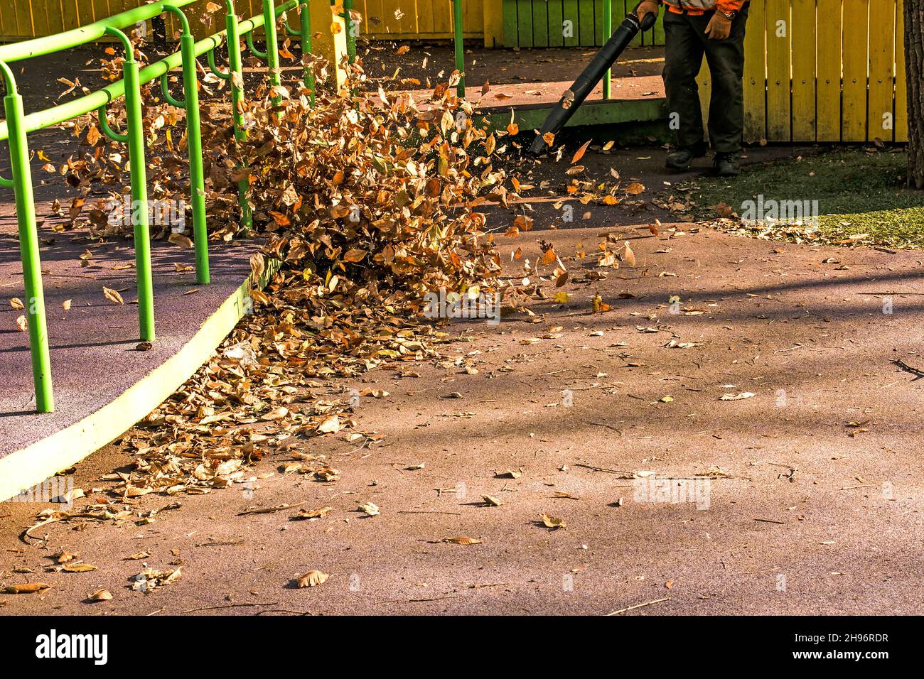 Pulizia foglie secche con un mulino a vento. Un lavoratore municipale pulisce il parco cittadino. Preparazione dei parchi cittadini per l'inverno. Foto Stock
