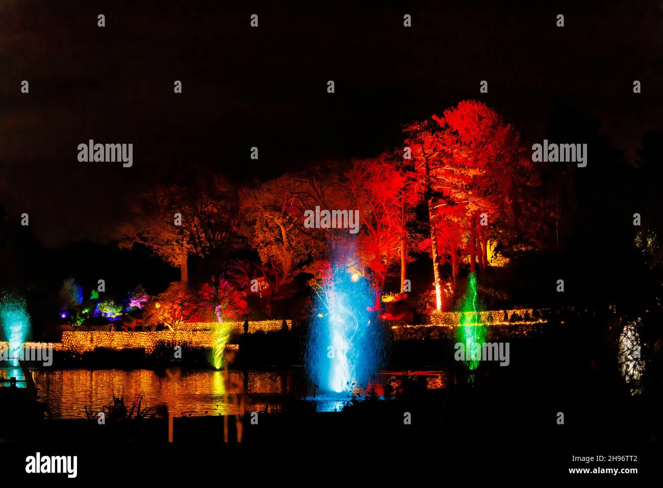 Fontane dai colori vivaci nel lago a Glow 2021, l'evento annuale di luci natalizie al RHS Garden, Wisley, Woking, Surrey Foto Stock