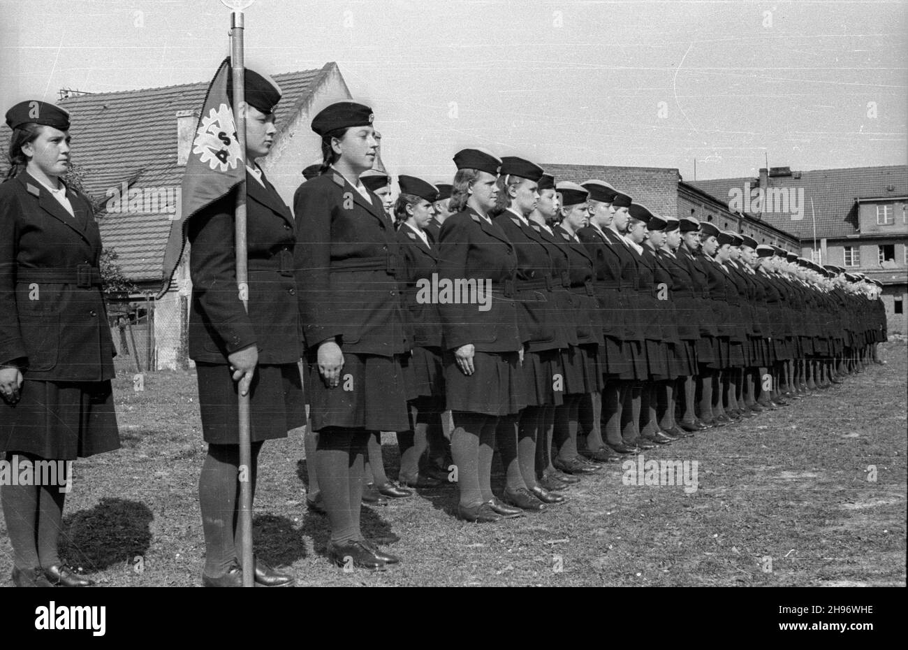 PRUDNIK, 1947-09. Szko³a Przysposobienia Przemys³owego nr 21 przy zak³adach bawe³nianych, podleg³a Ministerstwu Przemys³u i Handlu. NZ. Uczennice w mundurkach podczas apelu. Na pierwszym planie poczet sztandarowy. bk/mgs PAP Dok³adny dzieñ wydarzenia nieustalony. PRUDNIK, 1947 settembre. Scuola di formazione industriale n. 21 del Ministero dell'industria e del Commercio presso una fabbrica di cotone. Nella foto: Studenti in uniformi durante un'assemblea. In primo piano una festa a colori. bk/mgs PAP Foto Stock