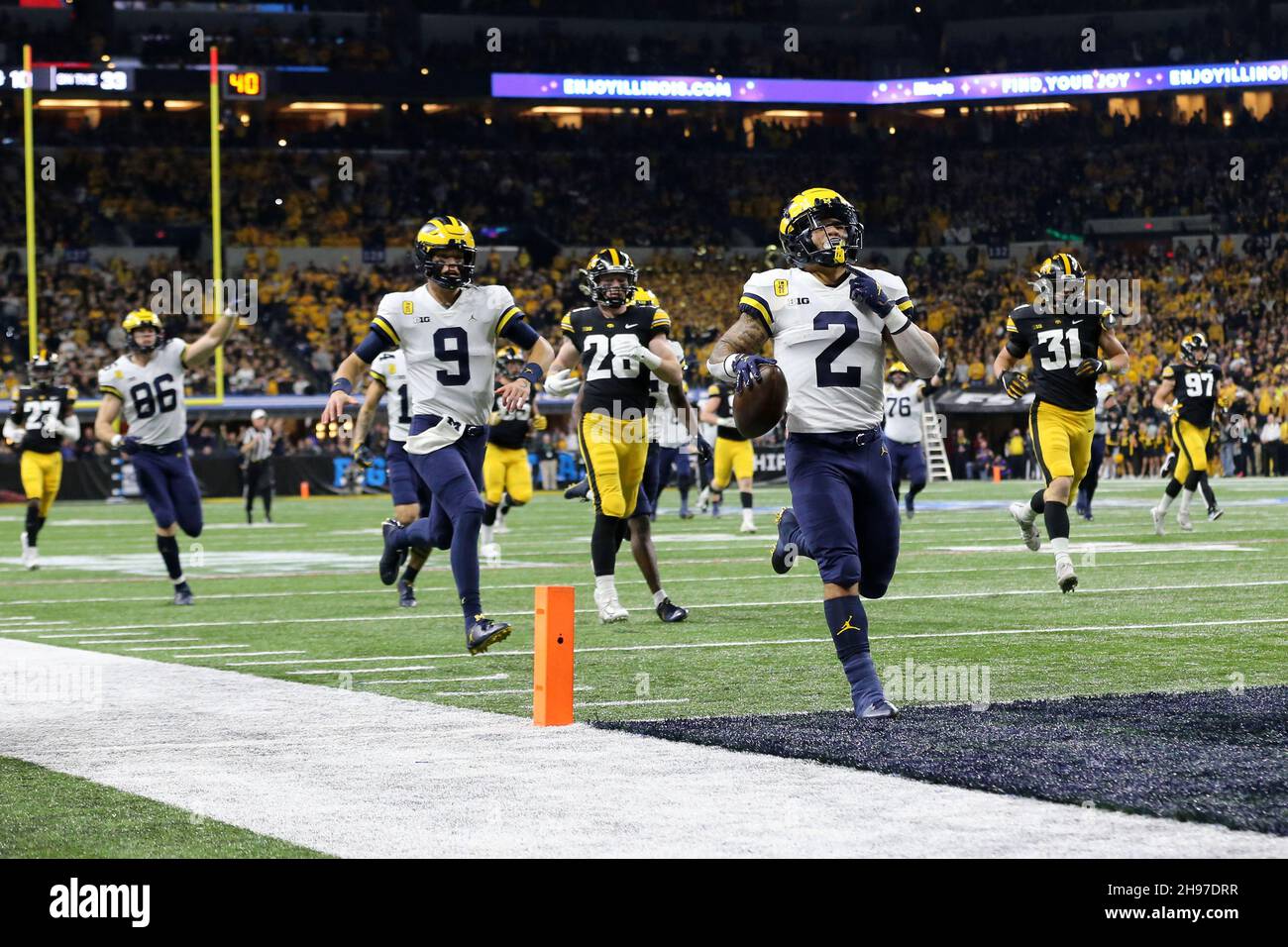 Indianapolis, Stati Uniti. 4 dicembre 2021. Michigan Wolverines Blake Corum (2) attraversa il cristallo per un touchdown nel primo trimestre contro gli Iowa Hawkeyes nella partita Big Ten Championship di Indianapolis, Indiana sabato 4 dicembre 2021. Foto di Aaron Josefczyk/UPI Credit: UPI/Alamy Live News Foto Stock