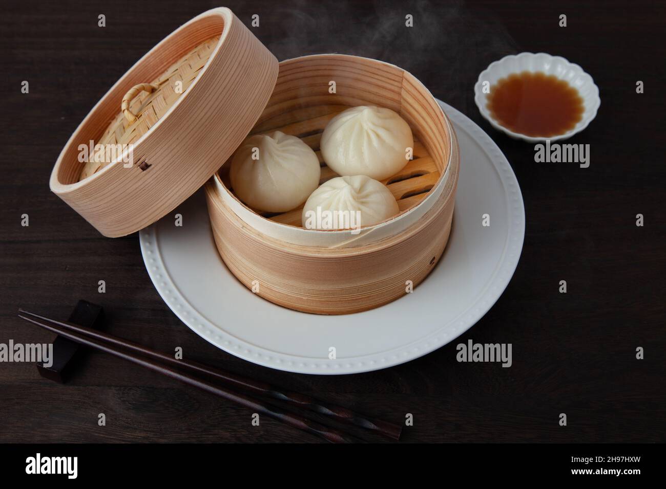 Xiaolongbao cinese mantou di mungere al vapore su tavolo di legno Foto Stock