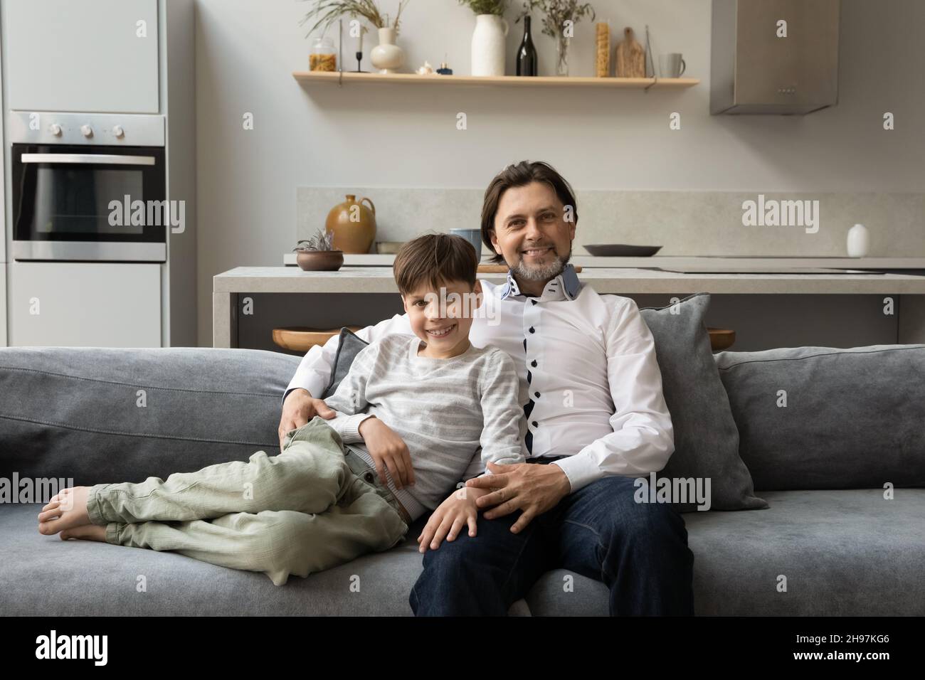 Allegro legame due generazioni maschio famiglia poggiando sul divano. Foto Stock