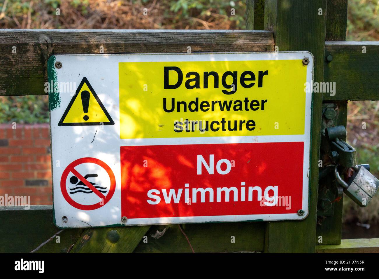 Un cartello di pericolo struttura subacquea presso la stazione di misura Stapleford avverte i passanti di non nuotare lì nel fiume Granta. Foto Stock