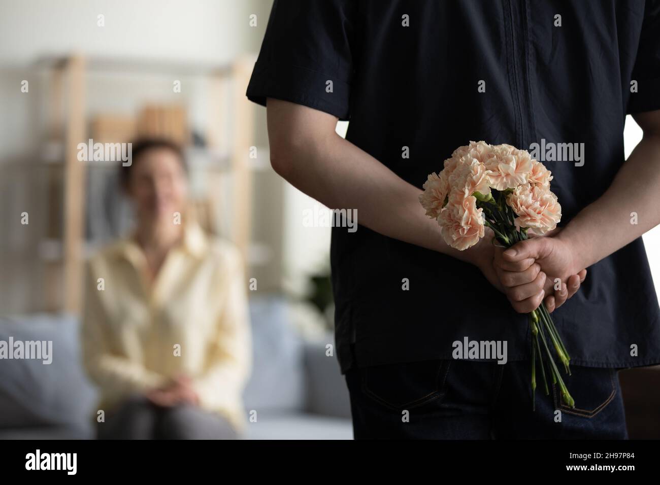 Mazzo di fiori in mani maschili dietro la schiena Foto Stock
