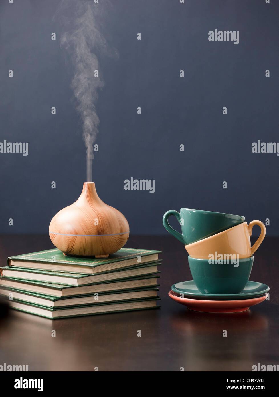 Relax a casa con olio aromatherapy diffusore, tè giallo, libro, bicchieri da lettura. Aroma essenza di salute, benessere aromaterapia casa aromatica Foto Stock