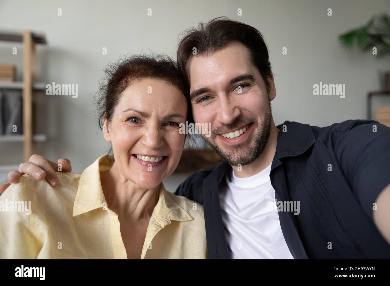 Figlio adulto felice e mamma matura che abbraccia con amore Foto Stock