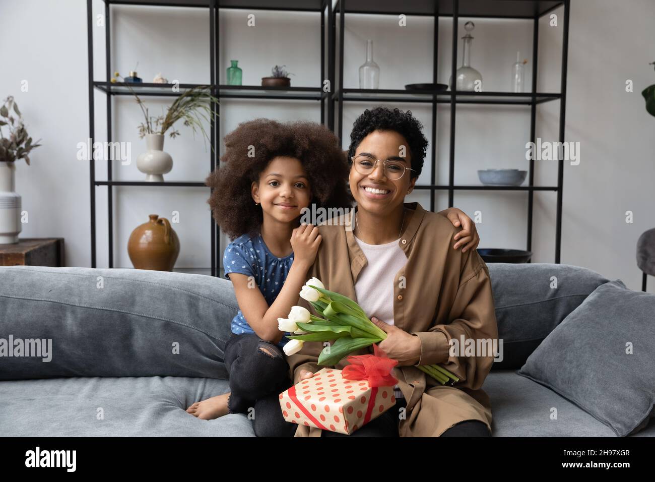 Ritratto di happy bonding famiglia afroamericana con regalo avvolto. Foto Stock