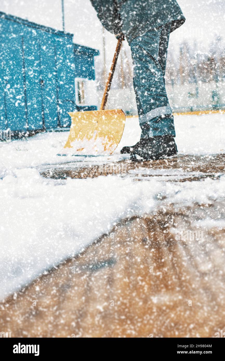 Janitor sgombrare la neve con una pala in legno. Pulizia strade dopo nevicate e Blizzard. Sfondo. Foto Stock