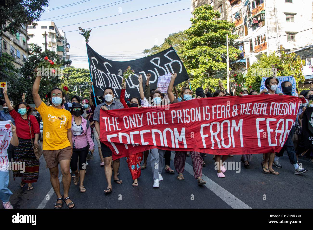 Circa 50 manifestanti militari che fanno il tre dito salutano e tenendo una grande bandiera con le parole 'l'unica prigione reale è paura e la libertà reale è libertà dalla paura' camminano lungo la strada per protestare contro il colpo di stato militare e hanno chiesto il rilascio di Aung San Suu L'esercito di Kyi.Myanmar ha arrestato il consigliere di Stato del Myanmar Aung San Suu Kyi il 01 febbraio 2021 e ha dichiarato uno stato di emergenza mentre coglie il potere nel paese per un anno dopo la perdita delle elezioni contro la Lega Nazionale per la democrazia (NLD). Molti manifestanti sono stati feriti dopo che le forze della giunta hanno aperto il fuoco o Foto Stock