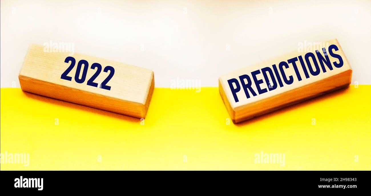 Blocchi di legno con previsioni del testo 2022 su sfondo bianco e giallo. Benefici per la salute, istruzione, affari, opportunità di lavoro, pensare in avanti Foto Stock
