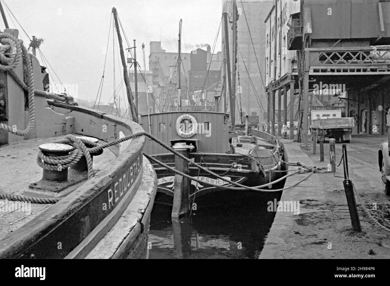 Il Wet Dock al porto di Ipswich, Suffolk, Inghilterra, Regno Unito fotografato nei suoi ultimi giorni di traffico commerciale a metà degli anni '60. Qui le chiatte del Tamigi sono ancora in uso, principalmente per il commercio del grano, sul fiume Orwell e sul Mare del Nord. Il centro è “Ena”, una chiatta di legno costruita nel 1906 presso il cantiere W B McLearon di Harwich, Essex. È una notevole “piccola nave” Dunkirk della seconda guerra mondiale, che si è resa nota per aver salvato 100 uomini nel 1940. Una grande rigenerazione dell’area ha avuto luogo dagli anni ’90 e l’attività commerciale del porto si trova ora più a valle – una fotografia d’epoca degli anni ’60. Foto Stock