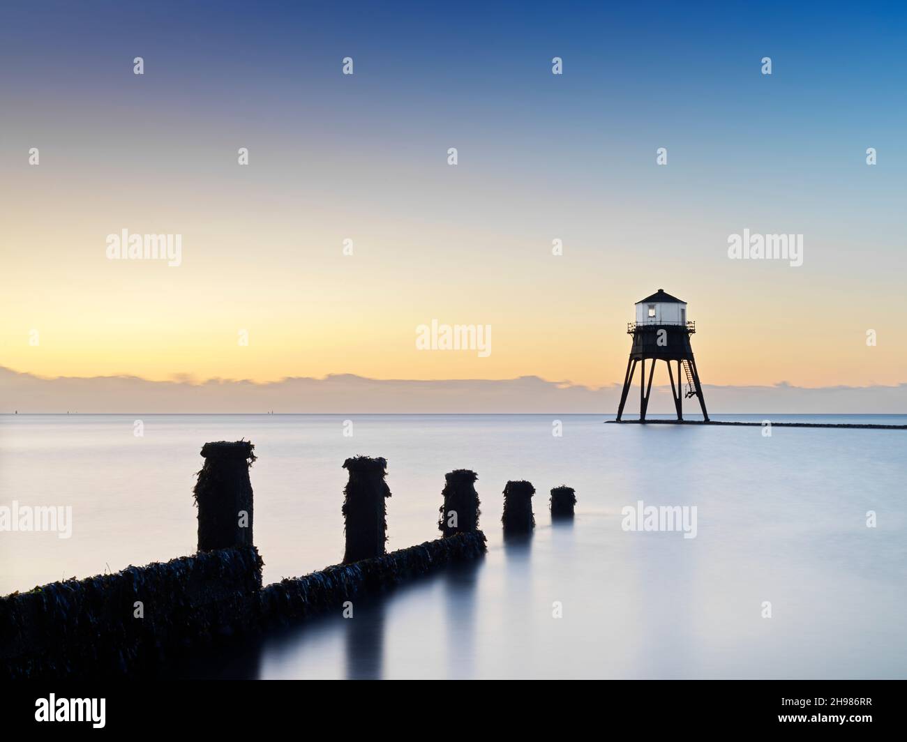 Dovercourt Low Light, Dovercourt Fari e Causeway, Essex, 2019. Vista generale verso sud verso il faro esterno al crepuscolo, con un groyne in primo piano, 2019. Foto Stock