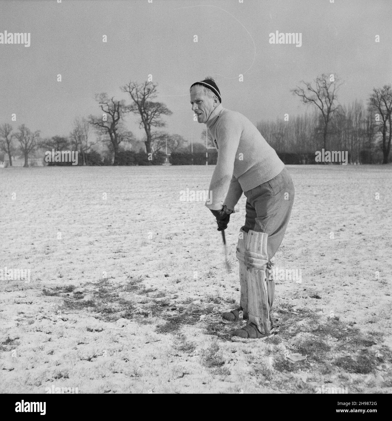 Alf Cannon, portiere della squadra di hockey del Laing's Sports Club, Barnet, Londra, 08/02/1956. Alf Cannon, portiere della squadra di hockey del Laing's Sports Club, gioca a hockey su un terreno innevato. Un'immagine simile è stata pubblicata nell'edizione di aprile 1956 della newsletter mensile Team Spirit di Laing, nella sezione 'personalità porte'. Alf era portiere della squadra di hockey, capitano e vice-capitano della squadra di cricket, e nel 1954 è stato vincitore congiunto del torneo maschile di tennis annuale doppio. Foto Stock