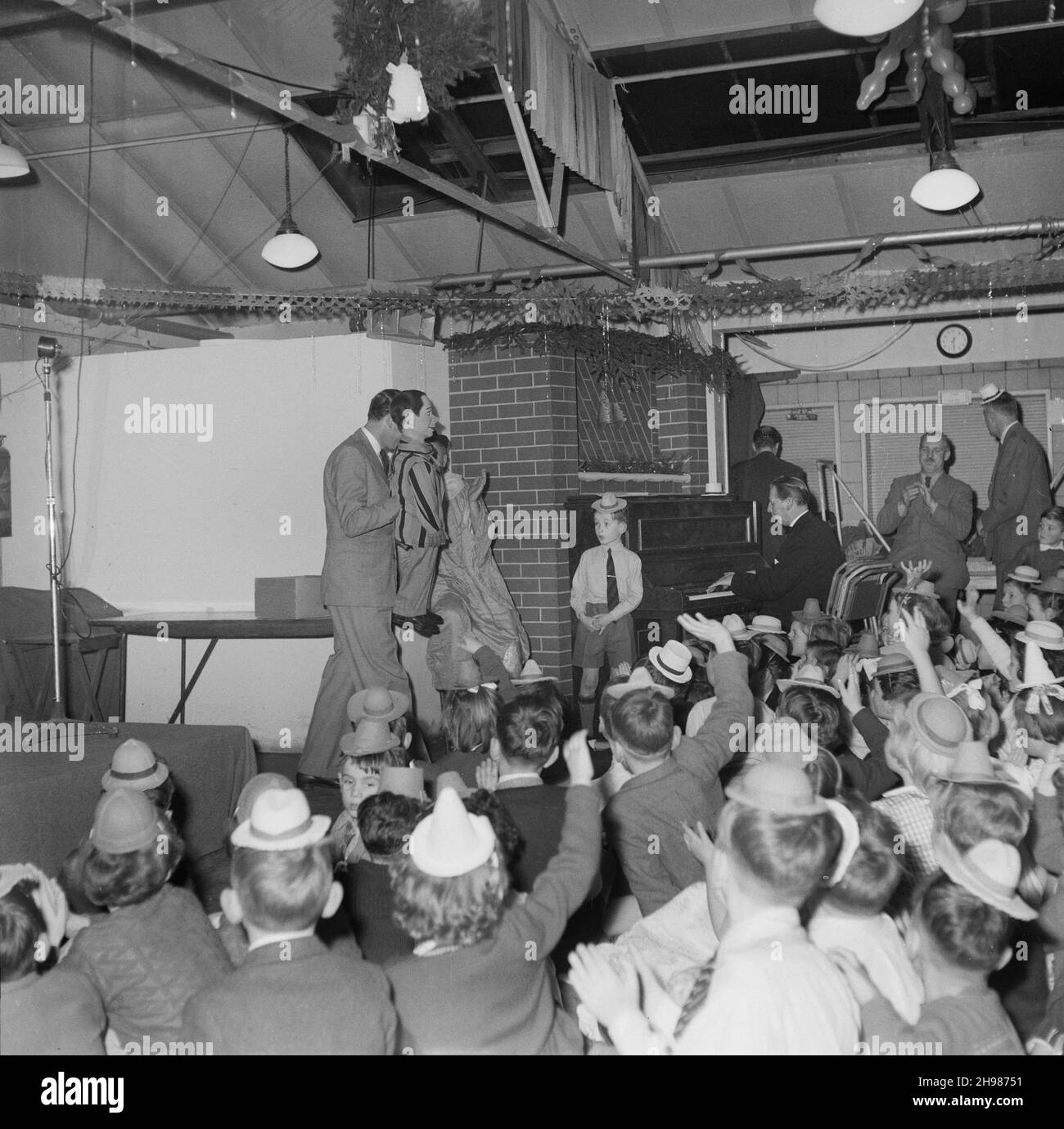 John Laing and Son Limited, Page Street, Mill Hill, Barnet, Londra, 17/12/1955. Un ventriloquist che intrattiene i bambini ad una festa di Natale. Questa festa di Natale è stata tenuta per i bambini del personale di Laing che ha lavorato presso l'ufficio di Mill Hill. Foto Stock