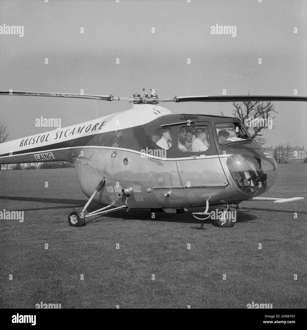 John Laing and Son Limited, Page Street, Mill Hill, Barnet, Londra, 30/04/1958. J M Laing con un gruppo di uomini a bordo dell'elicottero Bristol Sycamore di Laing. L'elicottero di Laing è stato utilizzato per fotografare e ispezionare i progressi nei loro cantieri come la London to Yorkshire Motorway (M1 Motorway). Foto Stock