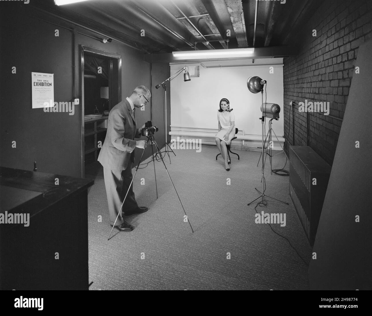 John Laing and Son Limited, Page Street, Mill Hill, Barnet, Londra, 11/05/1966. Un fotografo che scatta una foto di un modello nello studio del nuovo centro Sports Club subito dopo l'apertura del centro. Nel 1966, l'appartenenza al Laing Sports Club aveva raggiunto i 2,500 anni in tutto il paese. Una nuova ala Sports Club è stata inaugurata presso gli uffici di John Laing e Son Ltd a Mill Hill il 28 aprile 1966. Il nuovo centro aveva due piani, una sala biliardo, sale club, negozio sportivo, studio fotografico e uffici. Una caffetteria, una sala da ping pong e una sala TV sono state separate da porte pieghevoli e possono essere convertite Foto Stock