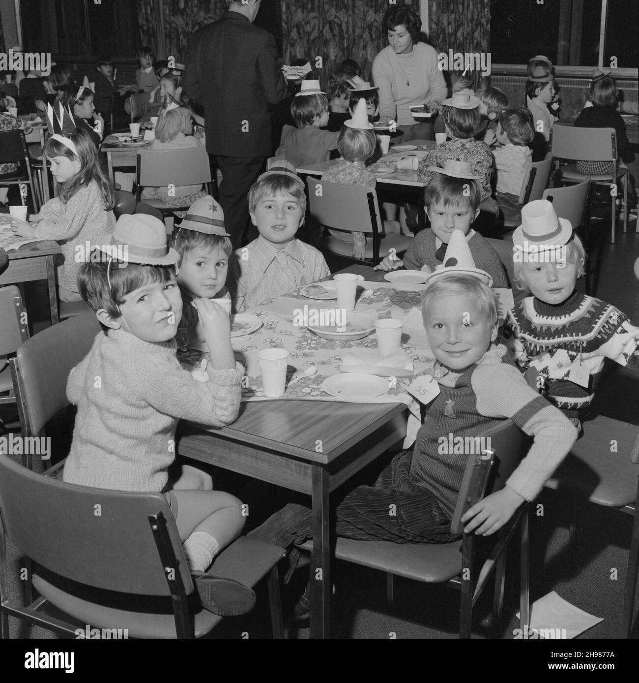 John Laing and Son Limited, Page Street, Mill Hill, Barnet, Londra, 18/12/1971. I bambini indossano cappelli da festa, hanno il tè ad una festa di Natale. Questo partito nella mensa dello staff di Laing presso il loro ufficio di Mill Hill è stato posato per oltre 150 bambini, con il cibo fornito dal reparto catering. Foto Stock