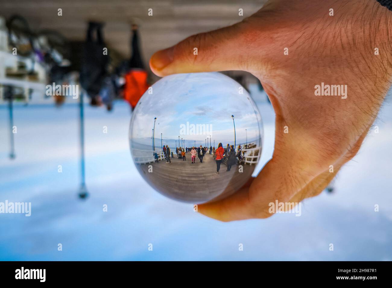 Gdansk, Polonia - Ottobre 24 2020: Molo a Brzezno al mattino nuvoloso riflesso in cristallo glassy lensball Foto Stock