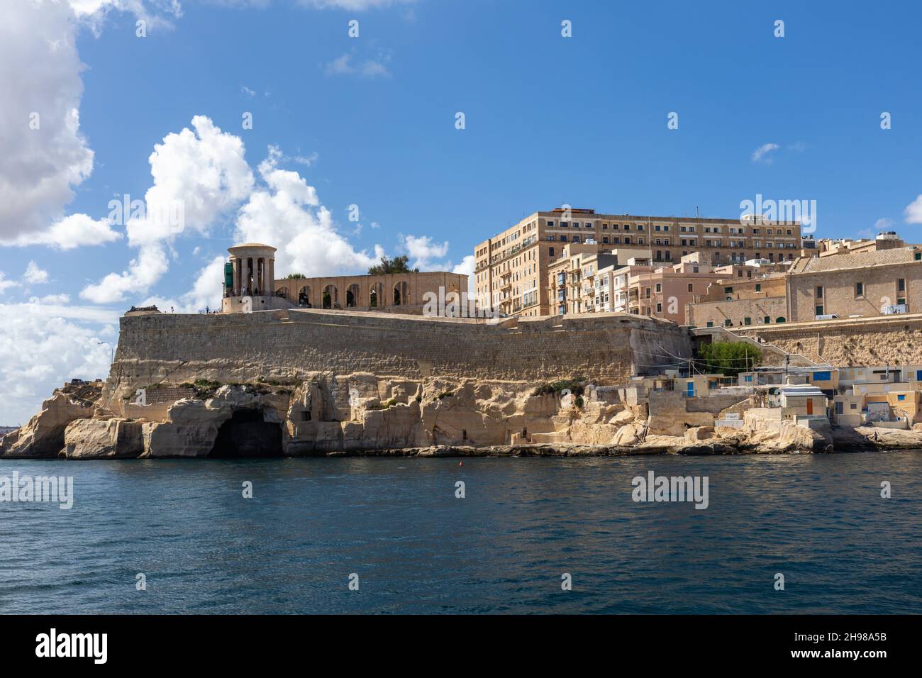 Monumento commemorativo della Campana dell'Assedio della seconda Guerra Mondiale nel Lower Barakka Garden visto da un tour del Grand Harbour, Malta, Europa Foto Stock