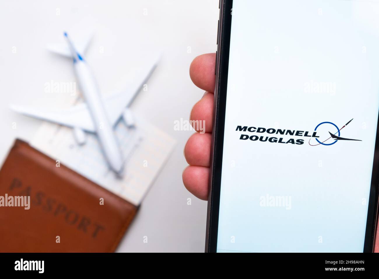 Logo McDonnell Douglas Airline sullo schermo del telefono cellulare con un aereo, passaporto e carta d'imbarco sullo sfondo. Il concetto dell'applicazione mobile delle compagnie aeree. Novembre 2021, San Francisco, USA Foto Stock