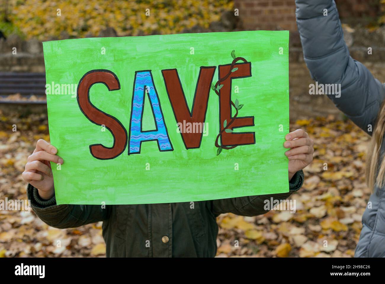 Ecologisti bambini che giocano per salvare il pianeta come inquinamenti tossici malvagi la terra rappresentata dall'attrice viola persona Antonia Stradivari Foto Stock
